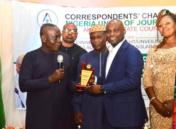 Senator Ita Enang presents the award to the representat